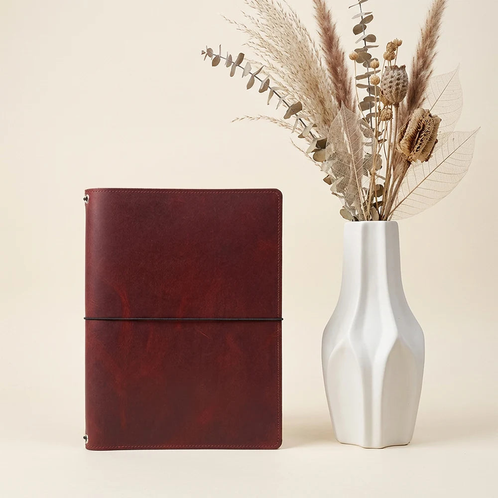 Genuine leather writing cover equipped with elastic loops for multiple notebook inserts.