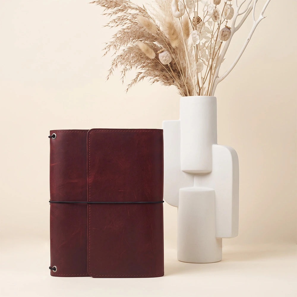 Handcrafted leather journal organizer with organized pocket layout and leather pen retention loop.