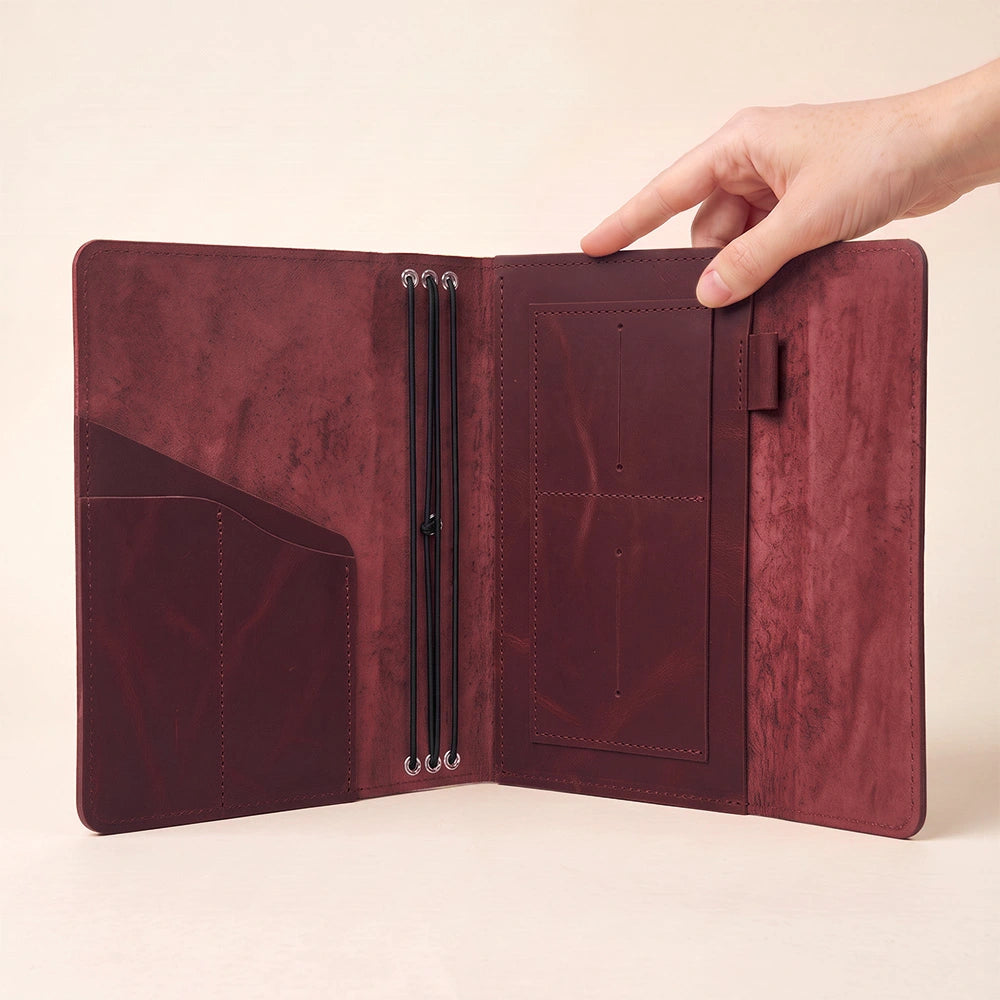 Handmade leather refillable planner organizer with practical storage and secure pen loop.