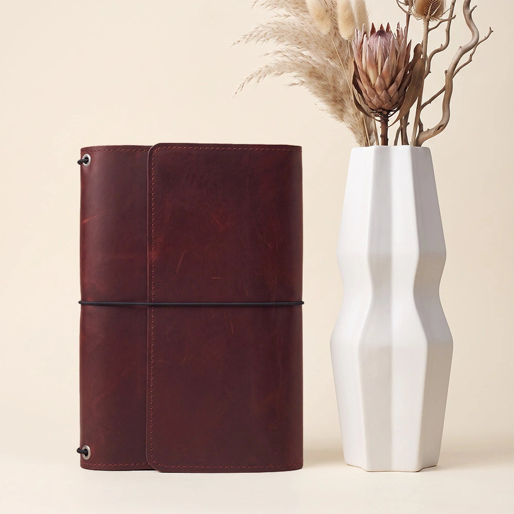 Premium leather notebook folder featuring interior accessory compartments and pen carrying strap.