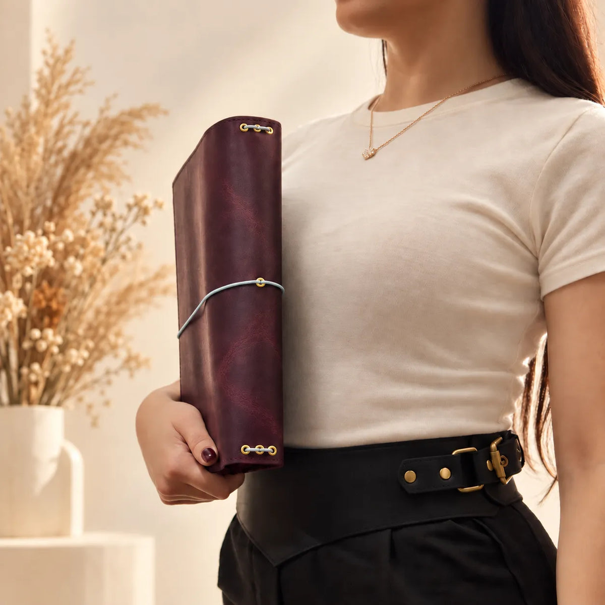 Woman holding a genuine leather journal cover and displaying its rustic natural texture.