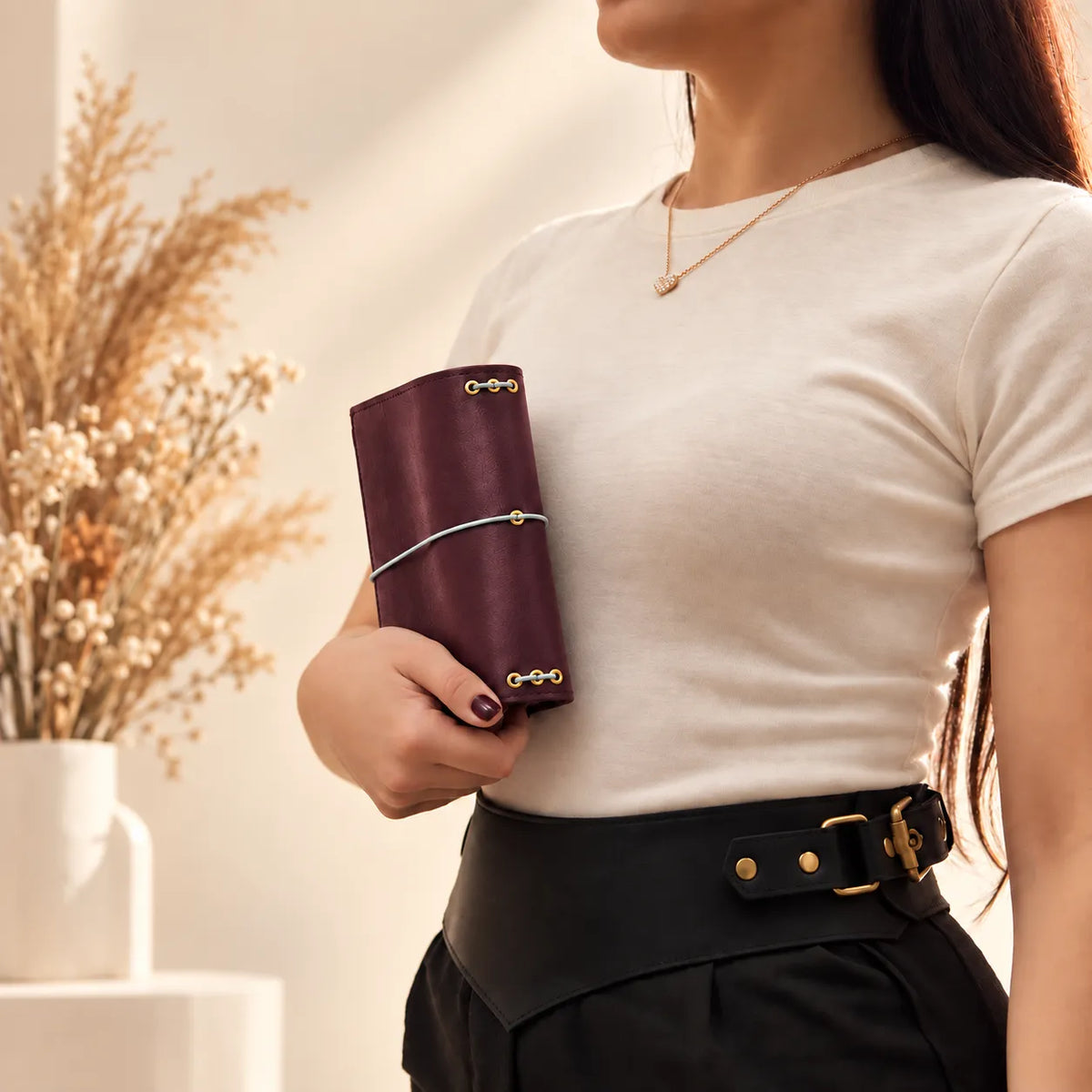 Woman holding a genuine leather cover for notebooks, emphasizing its durable handmade construction.