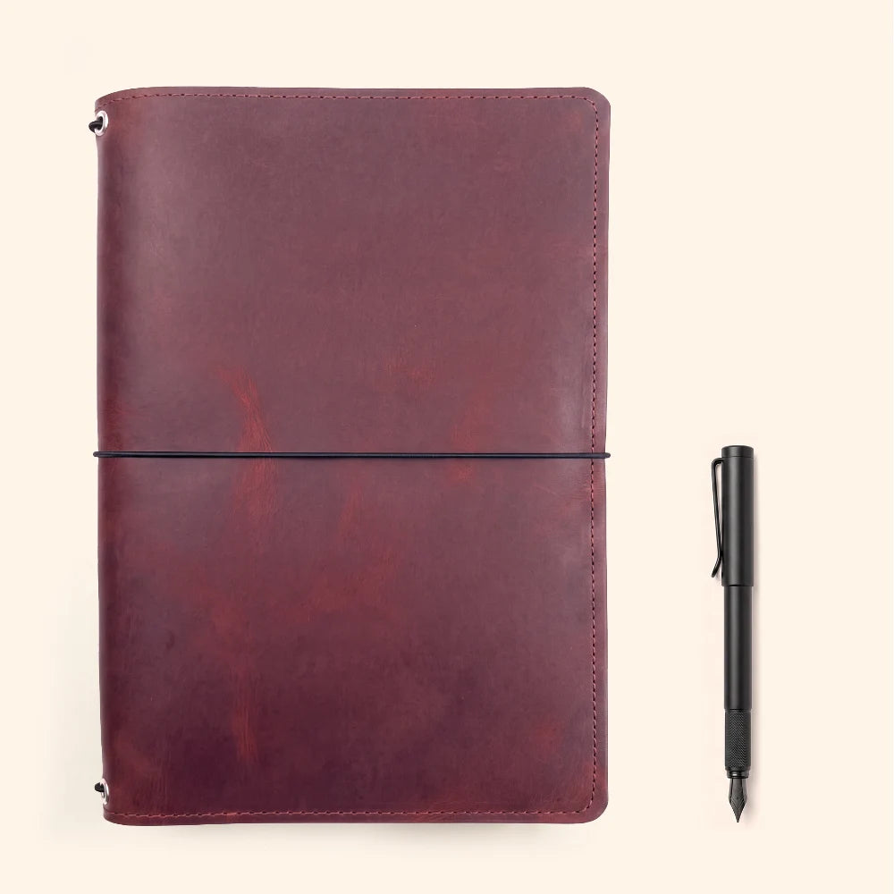 Leather journal sleeve with three interior elastic cords for modular notebook organization.