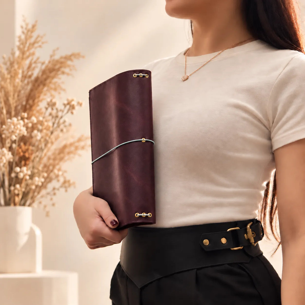 Woman holding a genuine leather journal cover, showing the detailed craftsmanship and textured surface.