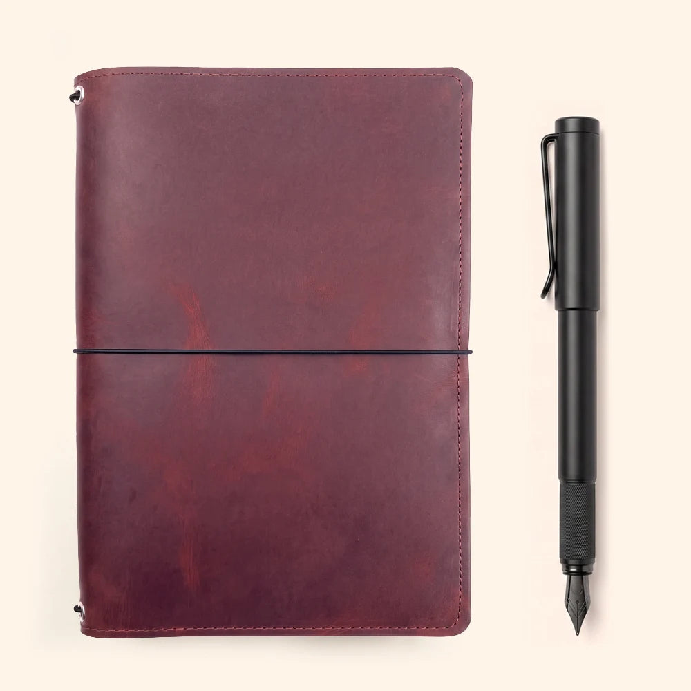 Refillable natural leather cover designed to securely organize three notebook inserts.
