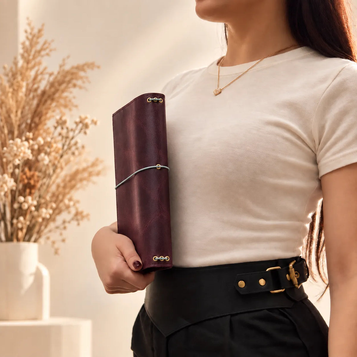 Woman holding a handcrafted notebook cover made from genuine leather with rustic details