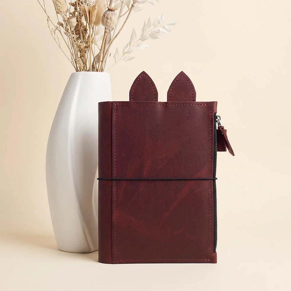 Handmade genuine leather cover featuring three elastic straps secured through metal eyelets.
