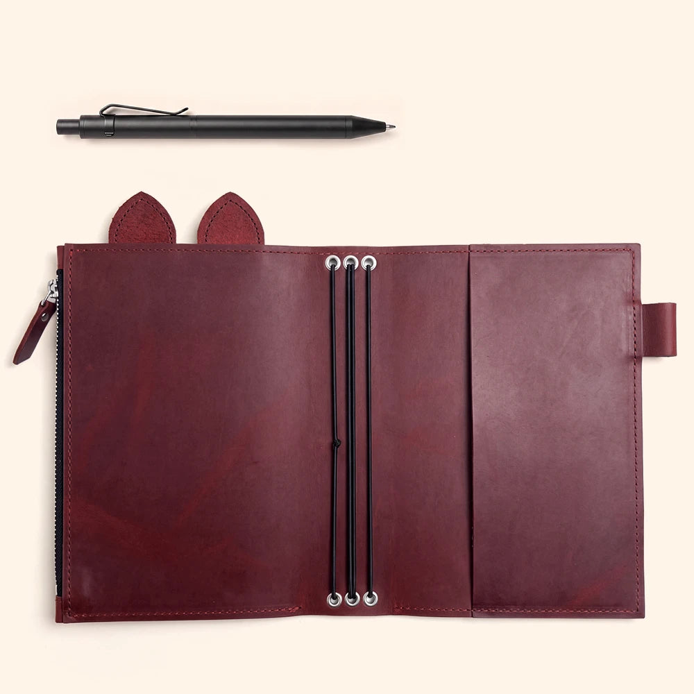 Leather notebook case with carefully stitched borders and an attached pen loop.