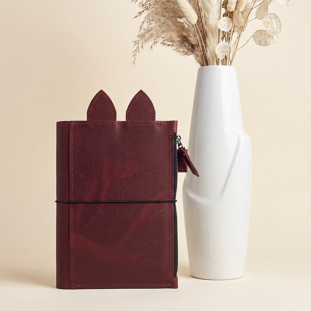 Handmade brown leather notebook cover with spacious zipper pocket, pen loop, decorative ears, and elastics.