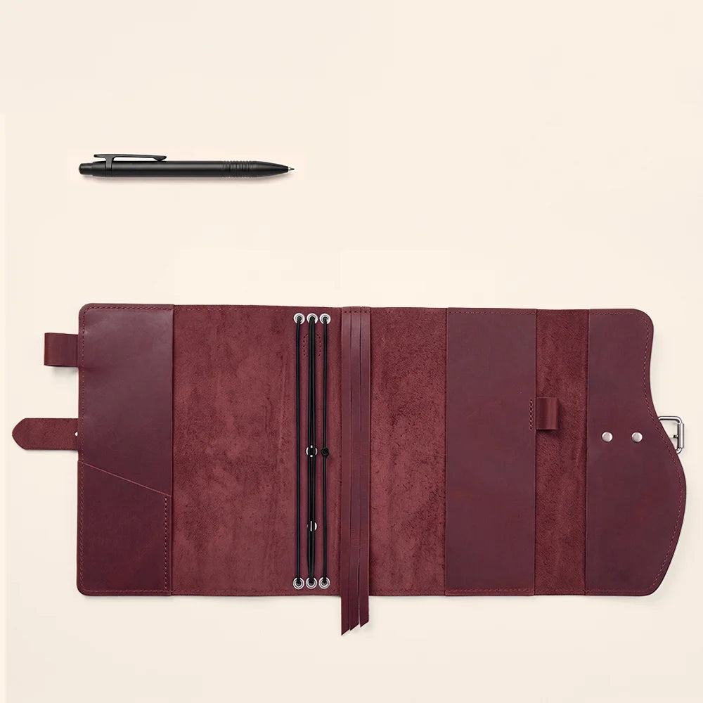 Handcrafted journal cover with natural leather, storage pockets, pen loop, ribbon marker, and carrying grip.