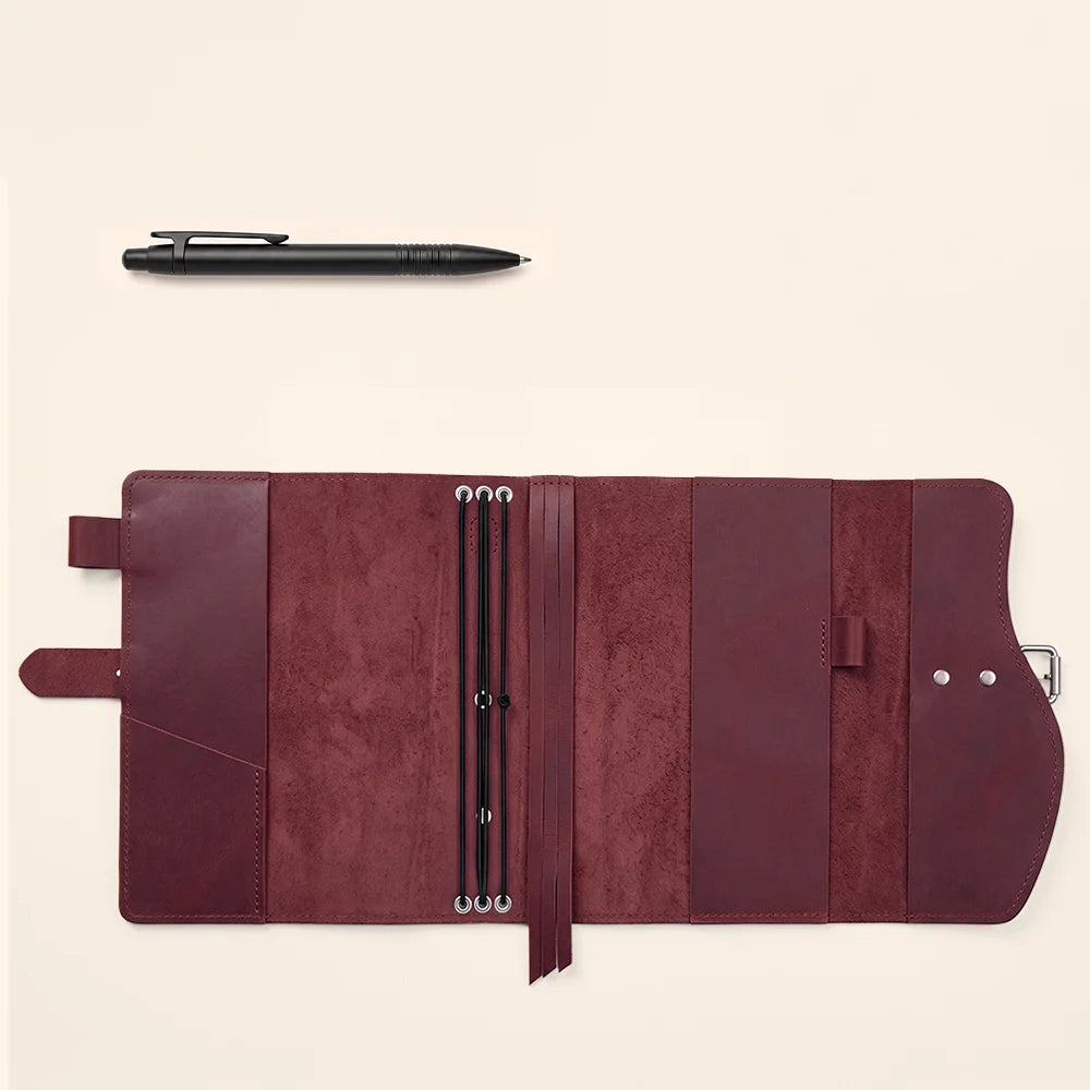 Durable leather journal carrier featuring interior slots, pen loop, integrated ribbon bookmark, and comfortable outer grip.