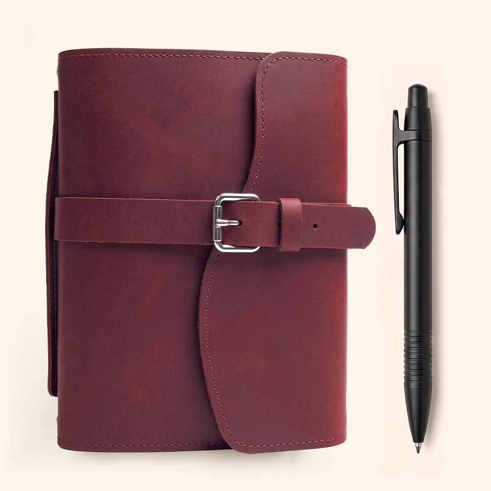 Textured leather notebook organizer with multiple inner compartments, elastic pen loop, bookmark ribbon, and carry handle.