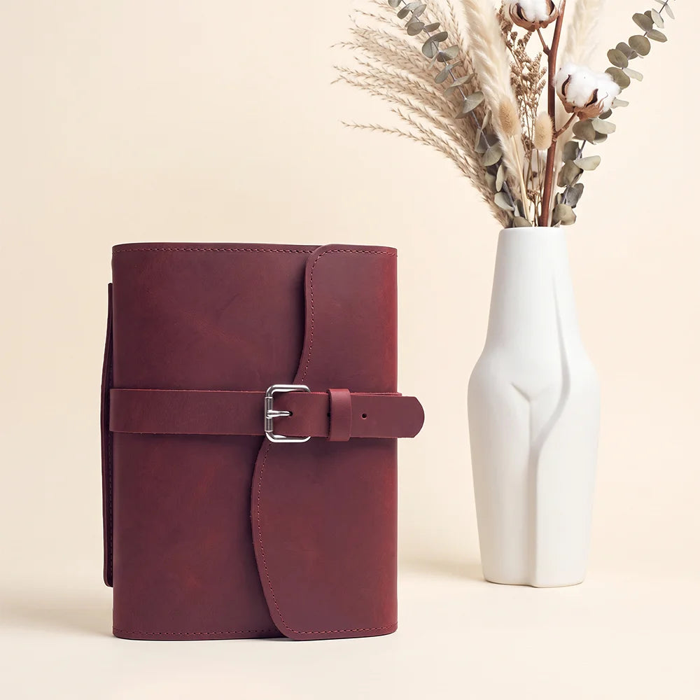 Handcrafted leather writing cover showcasing organized storage, elastic pen strap, ribbon bookmark, and portable exterior grip.