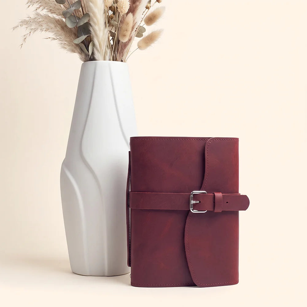 Handmade leather notebook organizer with spacious pockets, pen loop, integrated bookmark, and practical carrying handle.