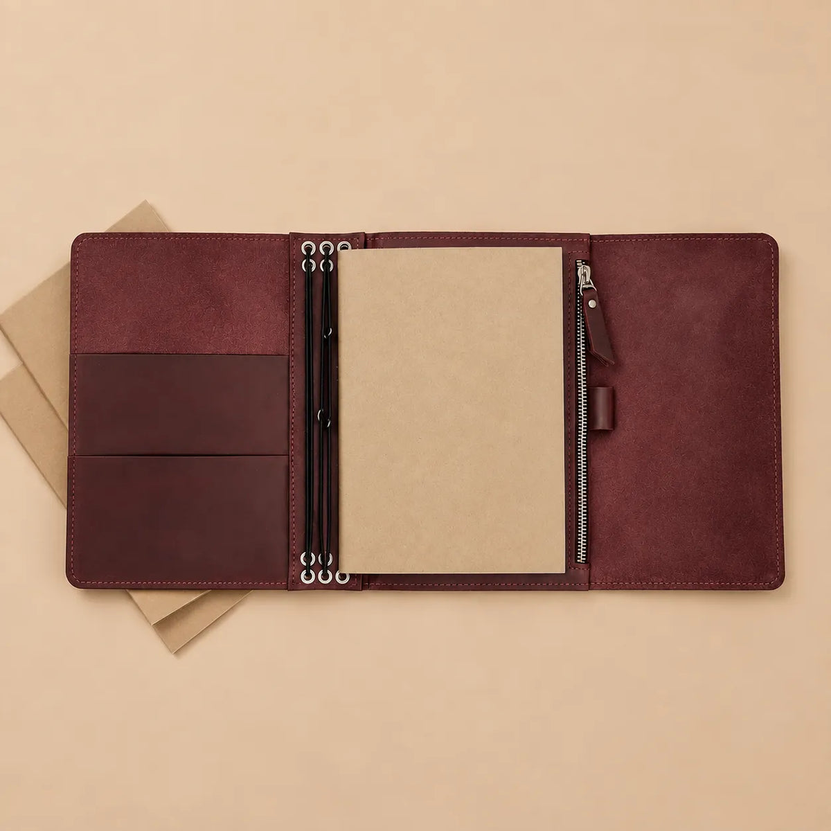 Burgundy leather notebook organizer with six elastics, interior pockets, large zipper pocket, and pen loop.