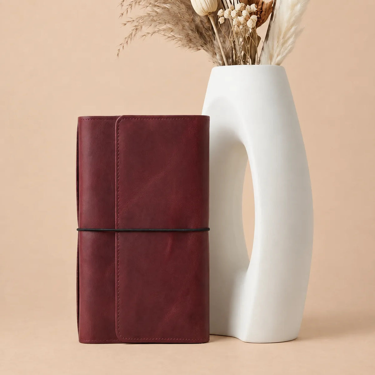 Burgundy leather journal organizer featuring six elastic bands, card pockets, zipper compartment, and pen loop.