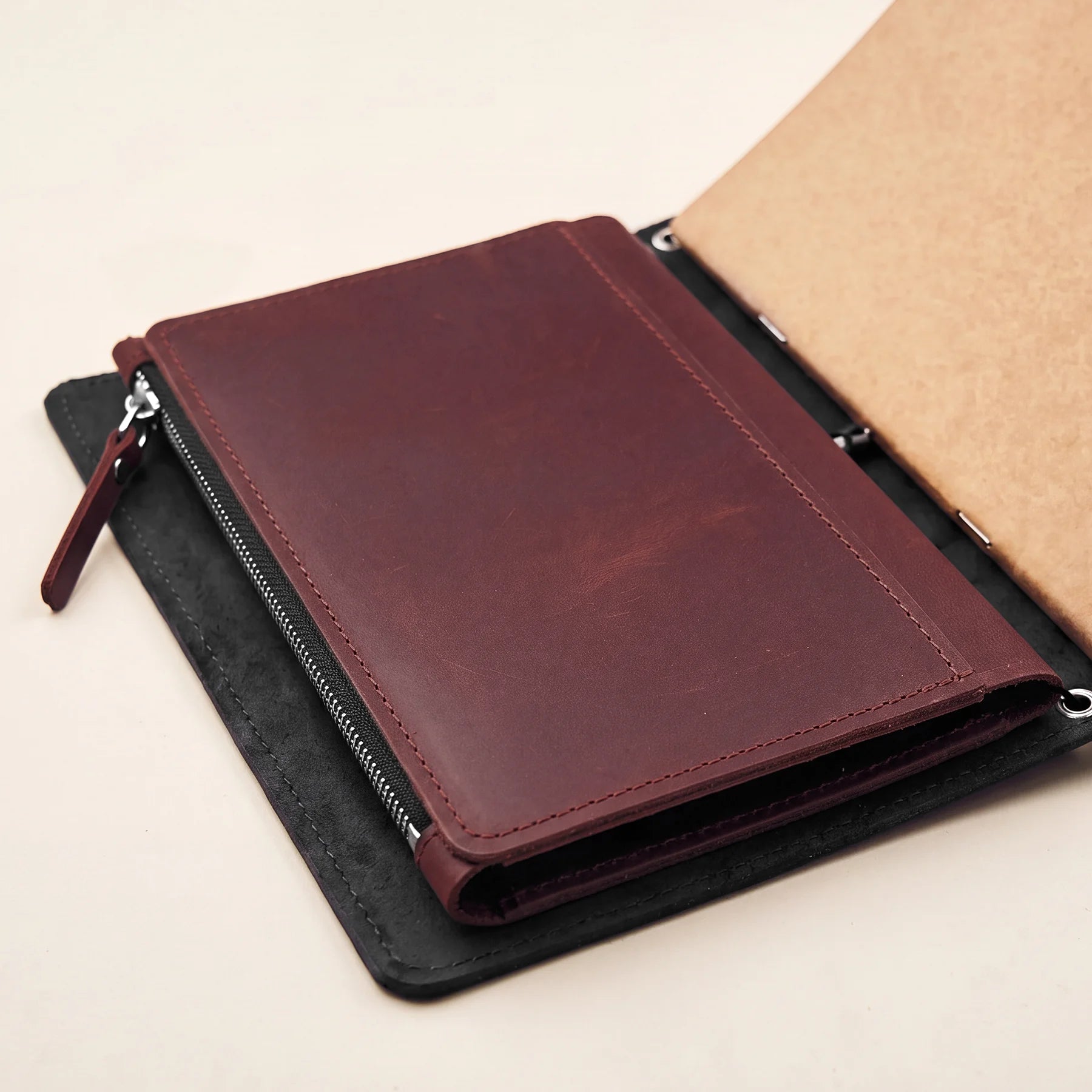 Minimalist leather notebook insert for travel journals with practical interior pockets.