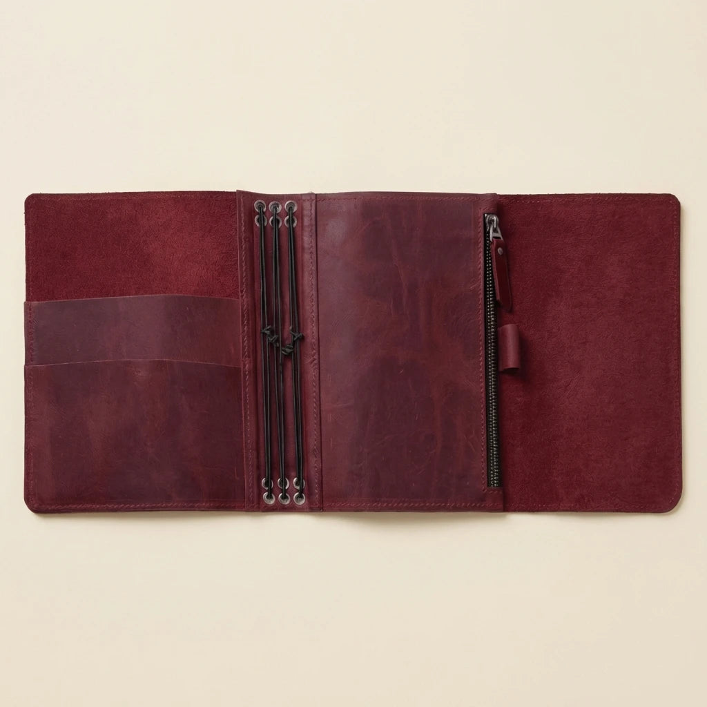 Brown leather journal with zippers on a beige background