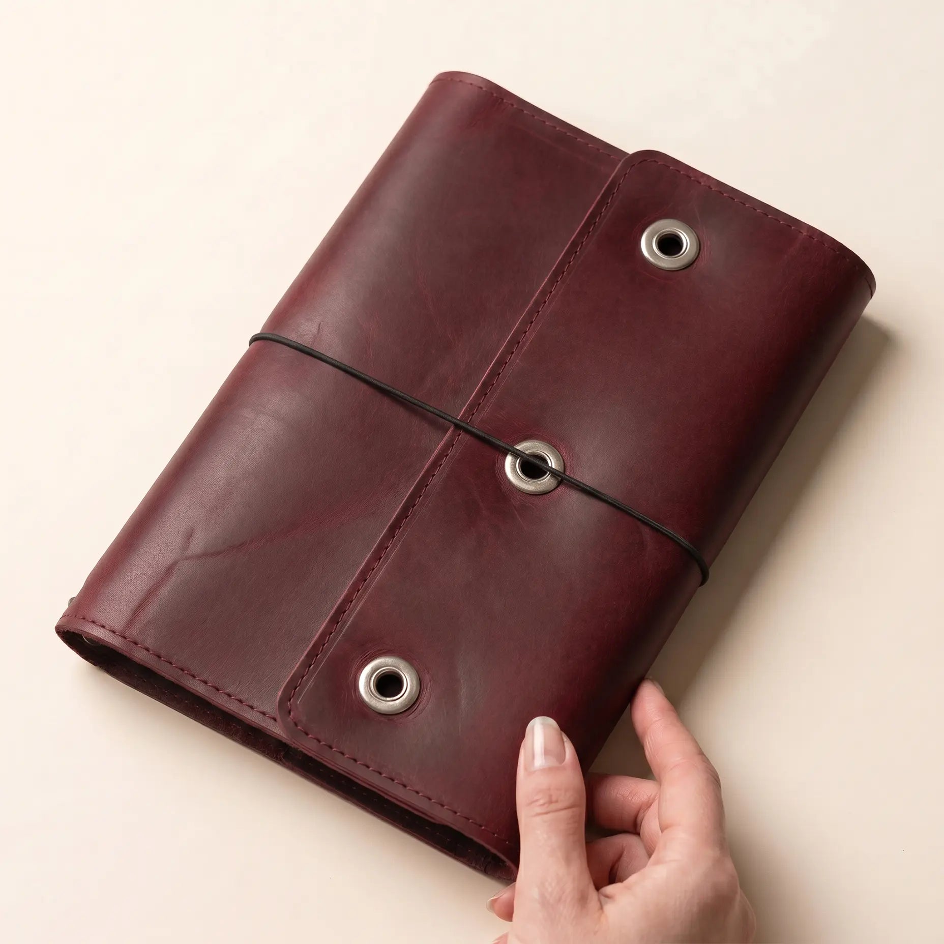 Elastic-bound leather journal cover with practical inner organization pockets.