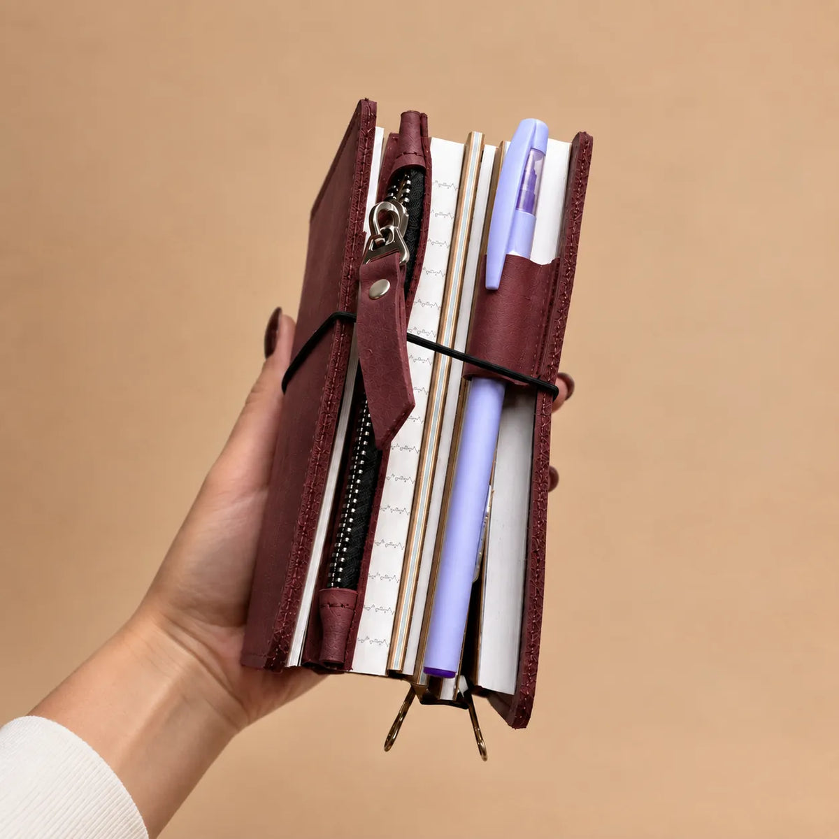 Genuine leather notebook cover designed with five elastic bands and storage pockets.