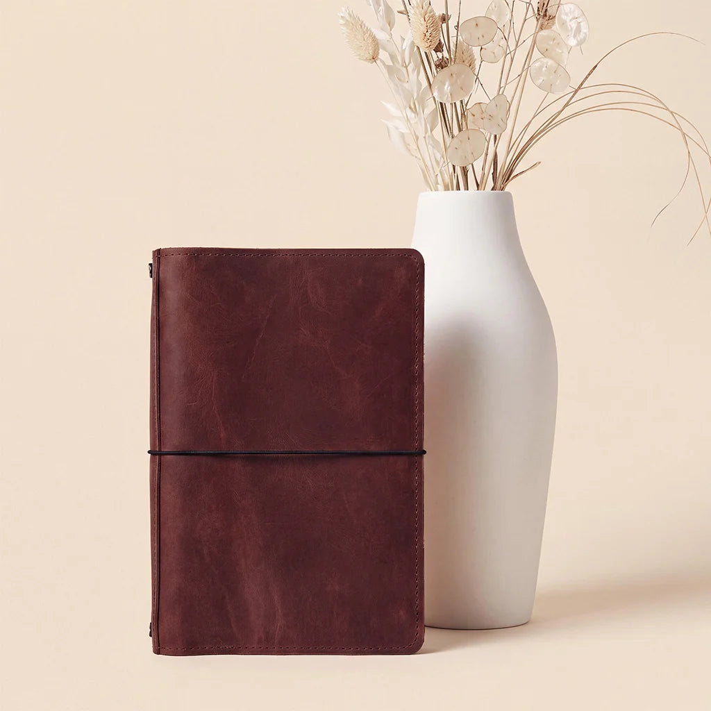 Leather notebook organizer featuring premium craftsmanship with refillable notebook elastic cords.