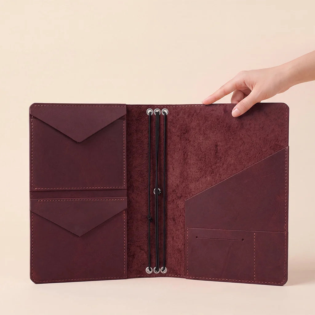 Handmade leather cover with organized inside storage and refillable elastic notebook support.
