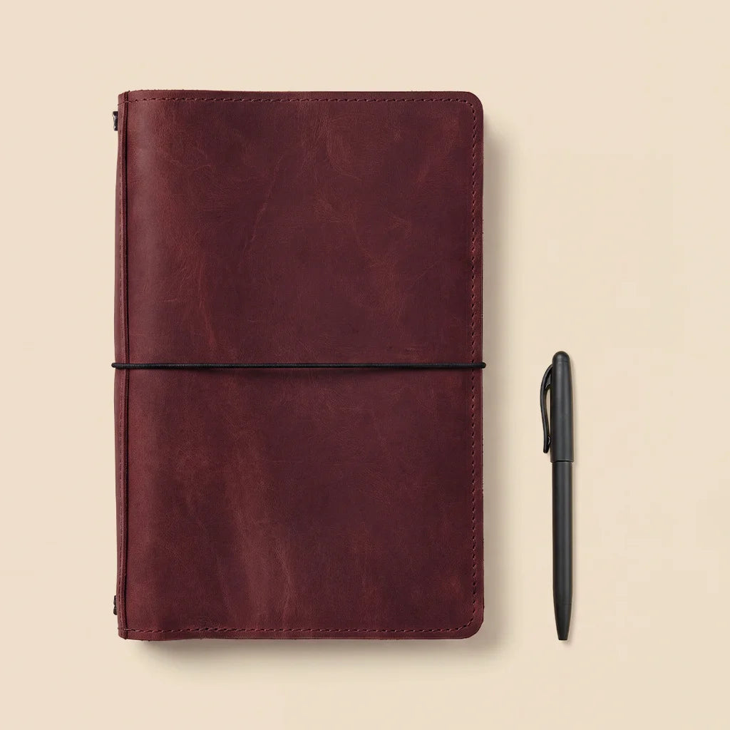 Genuine leather planner cover with practical organizer design and elastic notebook attachment.