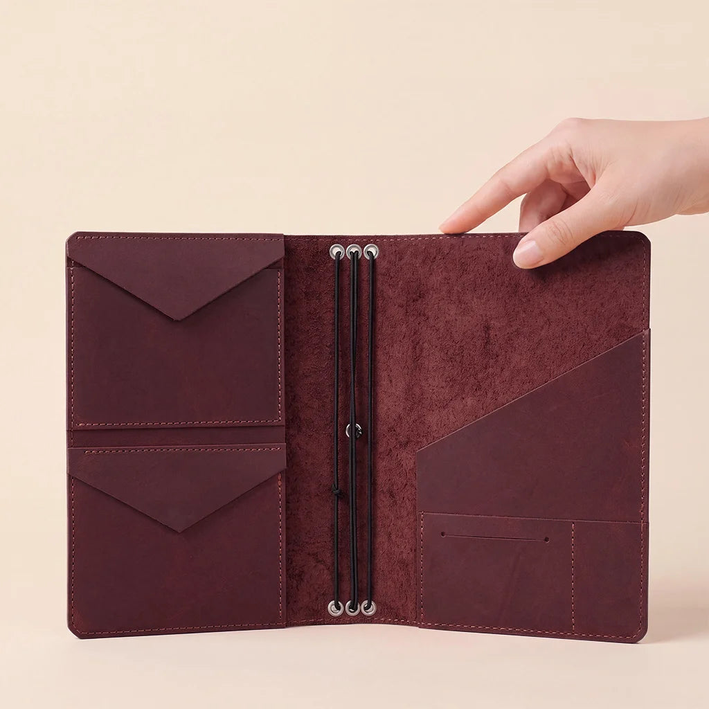 Genuine leather refillable journal cover featuring interior pockets and notebook securing elastic bands.