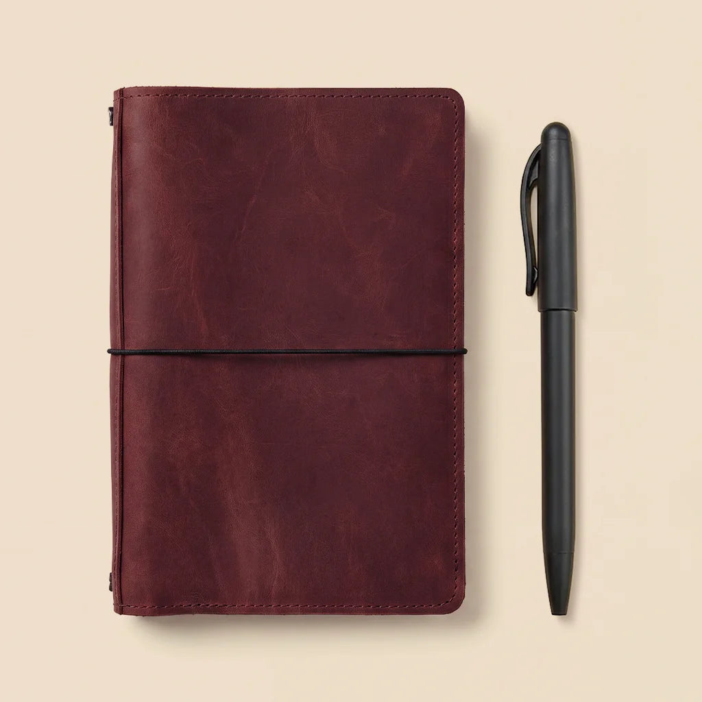 Leather notebook cover with spacious pockets and elastic bands for travel journaling essentials.