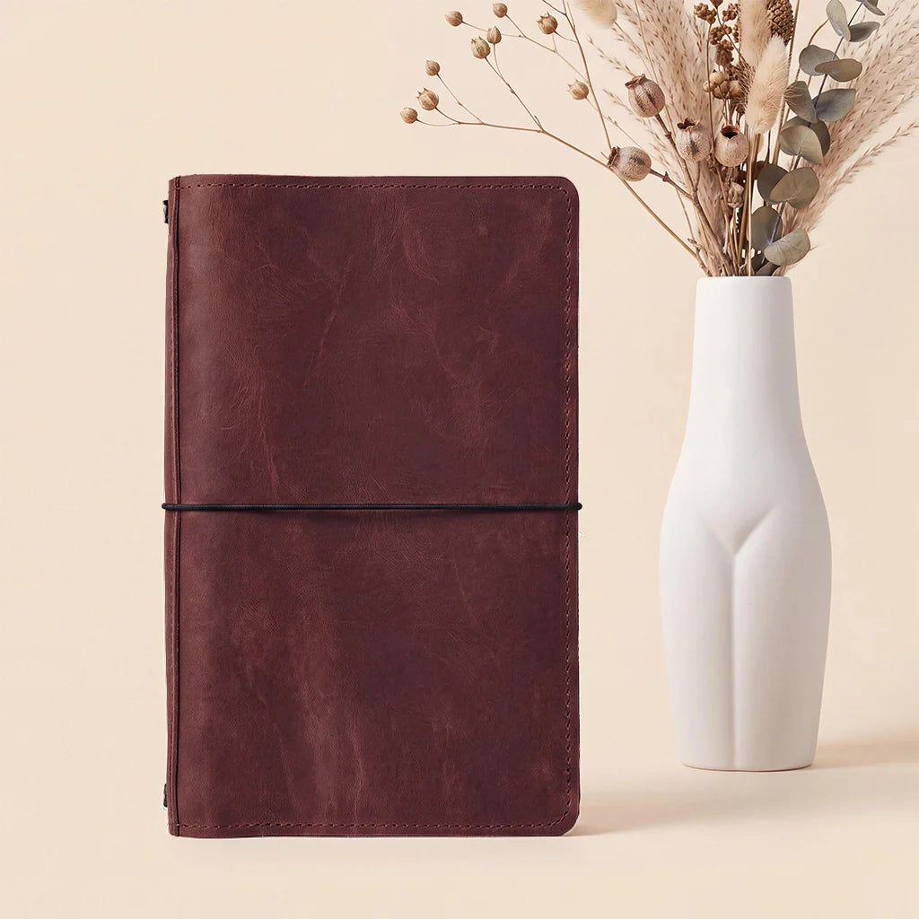 Leather planner cover featuring handcrafted stitching, organizer compartments, and elastic notebook bands.