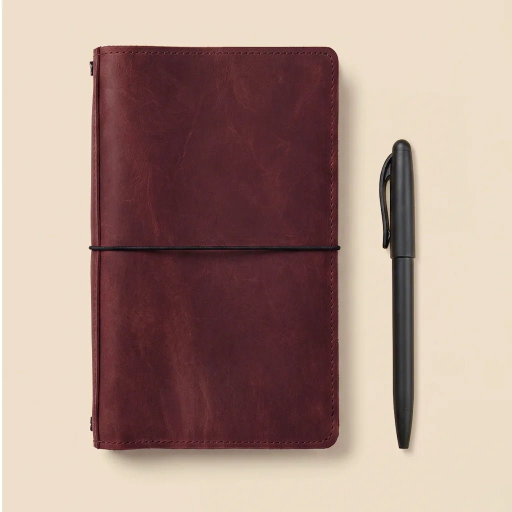 Handmade journal cover crafted from genuine leather with interior storage and elastic loops.