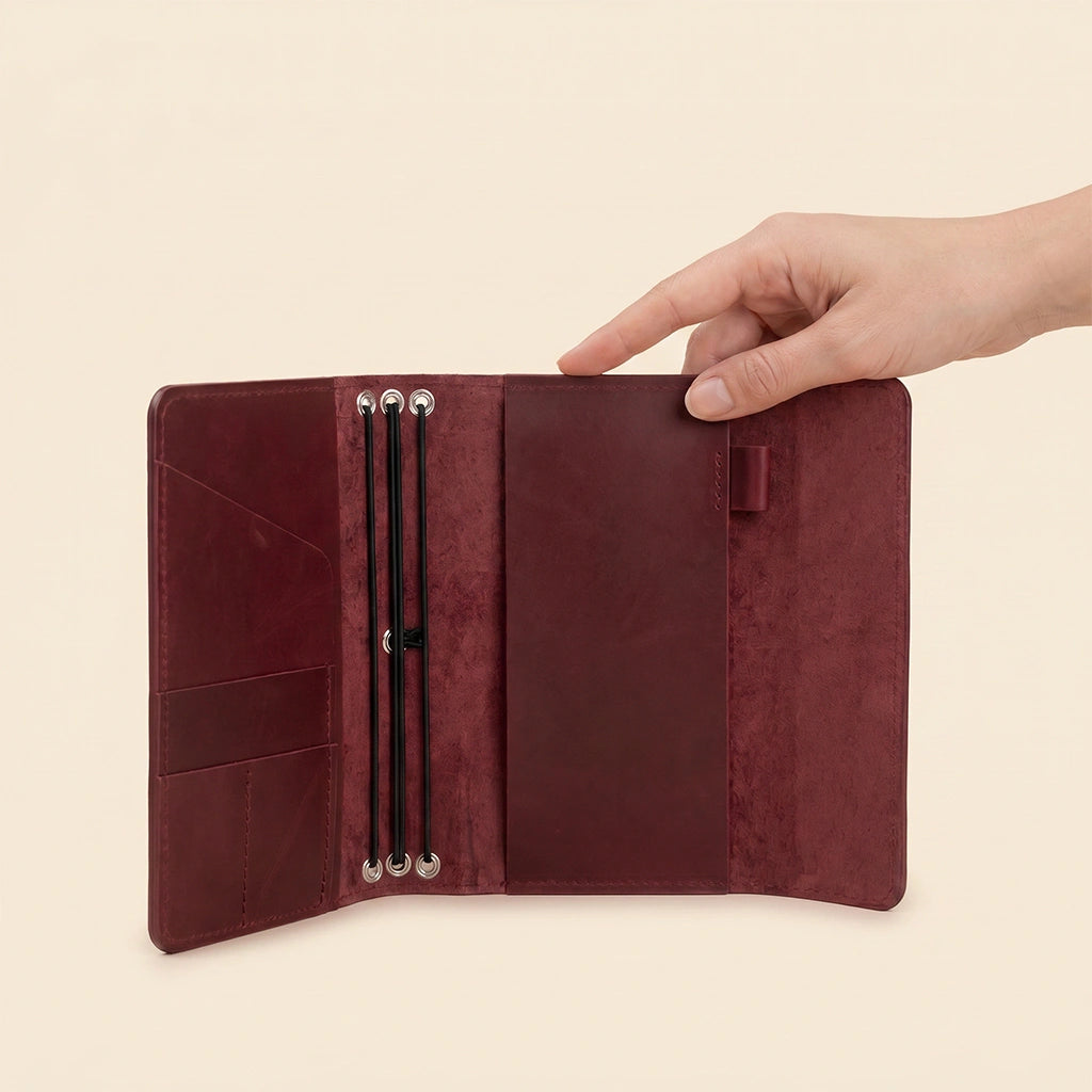 Refillable leather notebook holder featuring practical interior pockets and comfortable pen loop.