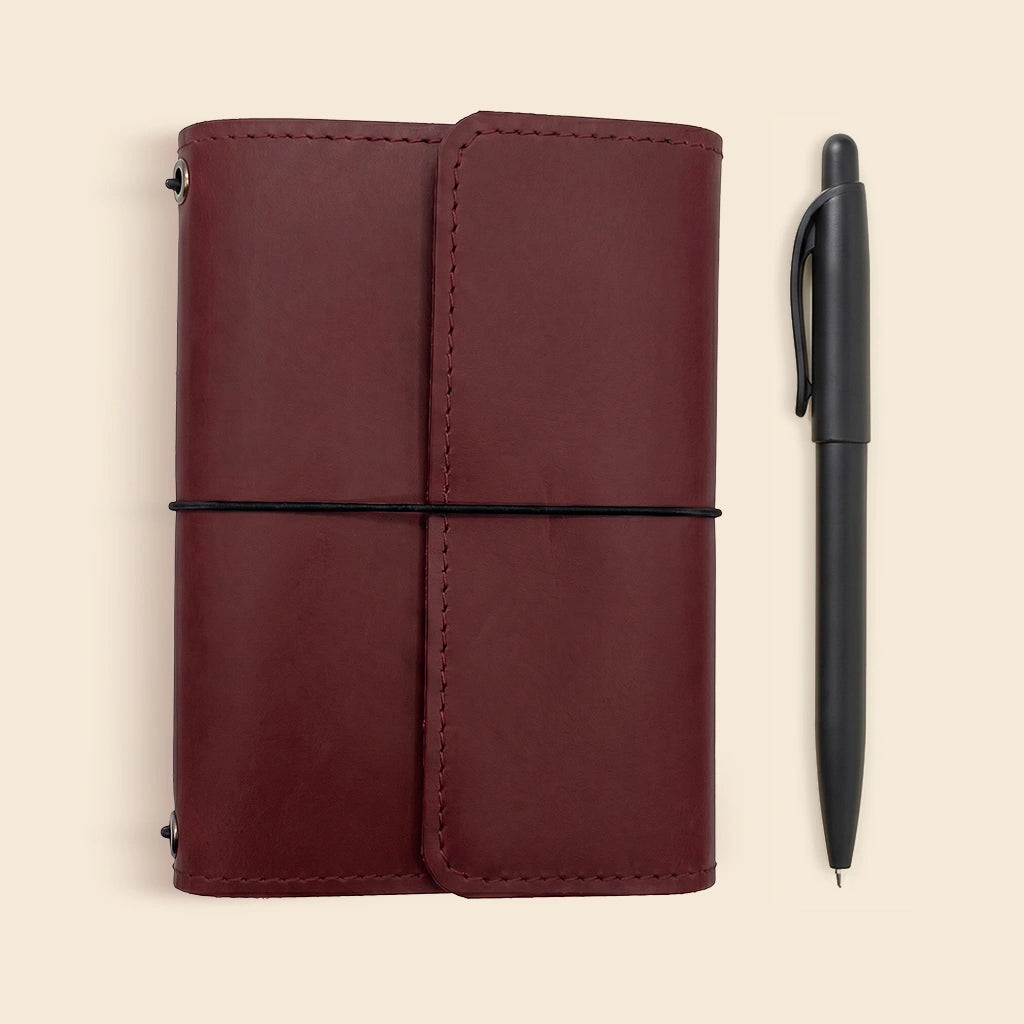 Handmade leather journal cover with flexible elastic notebook bands and storage pockets.