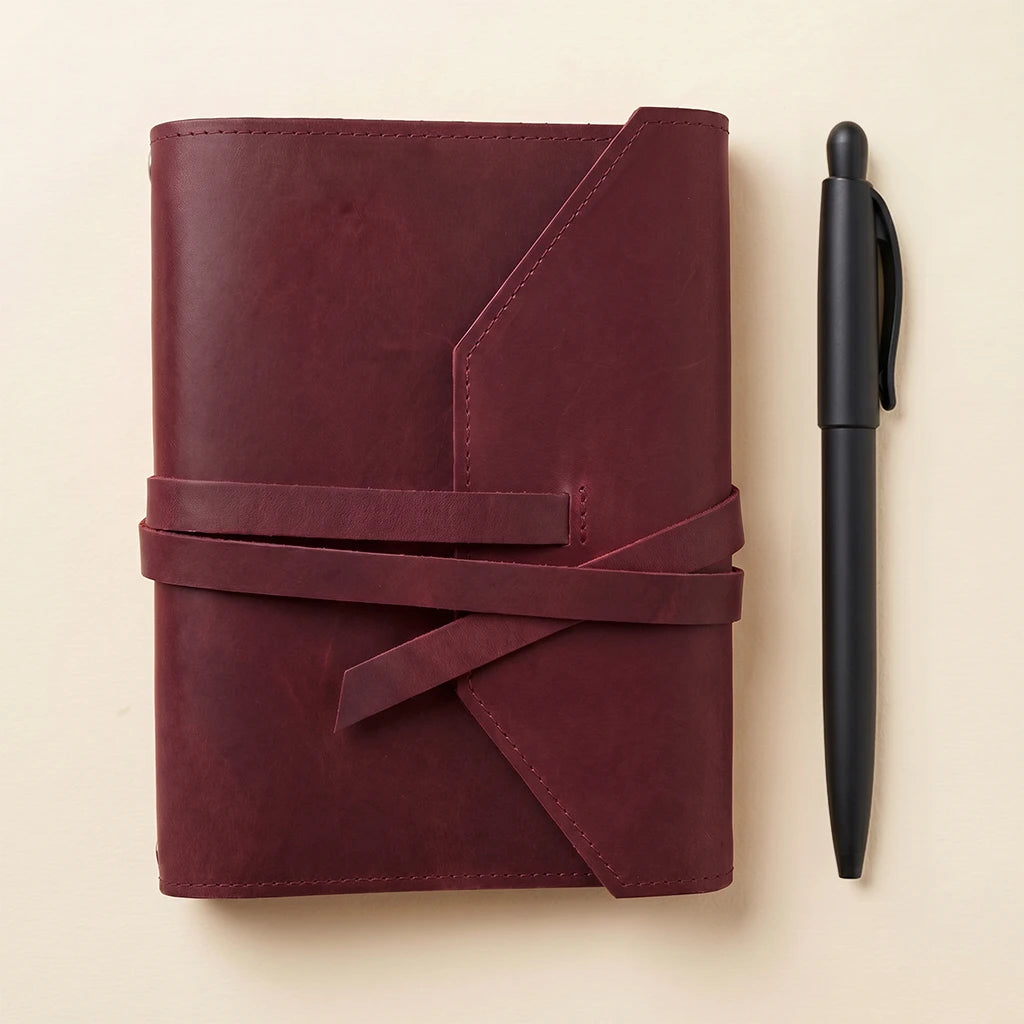 Compact leather notebook cover with elastic fastening and convenient pen loop.