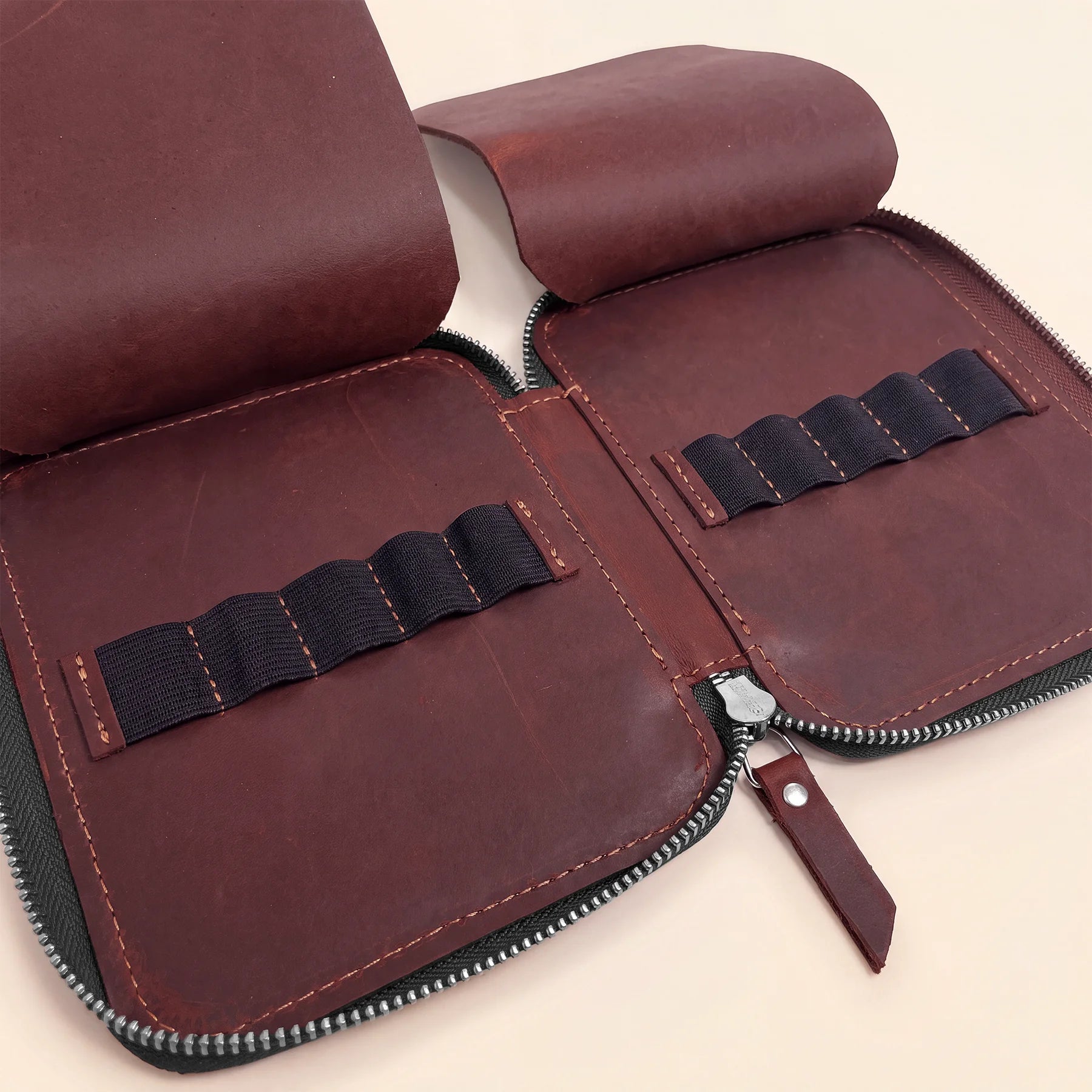 Minimalist leather pen organizer featuring zipper closure and premium genuine leather craftsmanship.