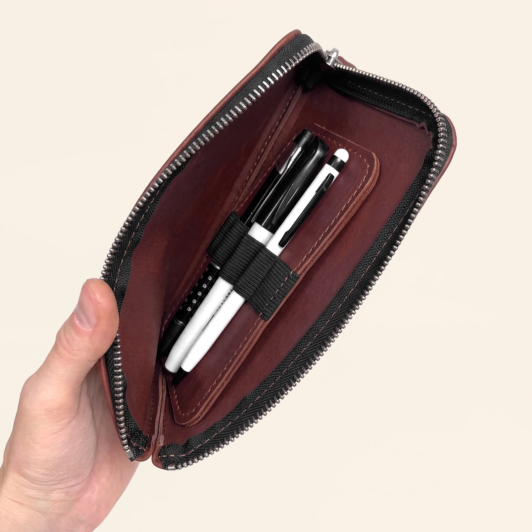 Compact leather organizer wallet with zipper for storing favorite writing instruments.