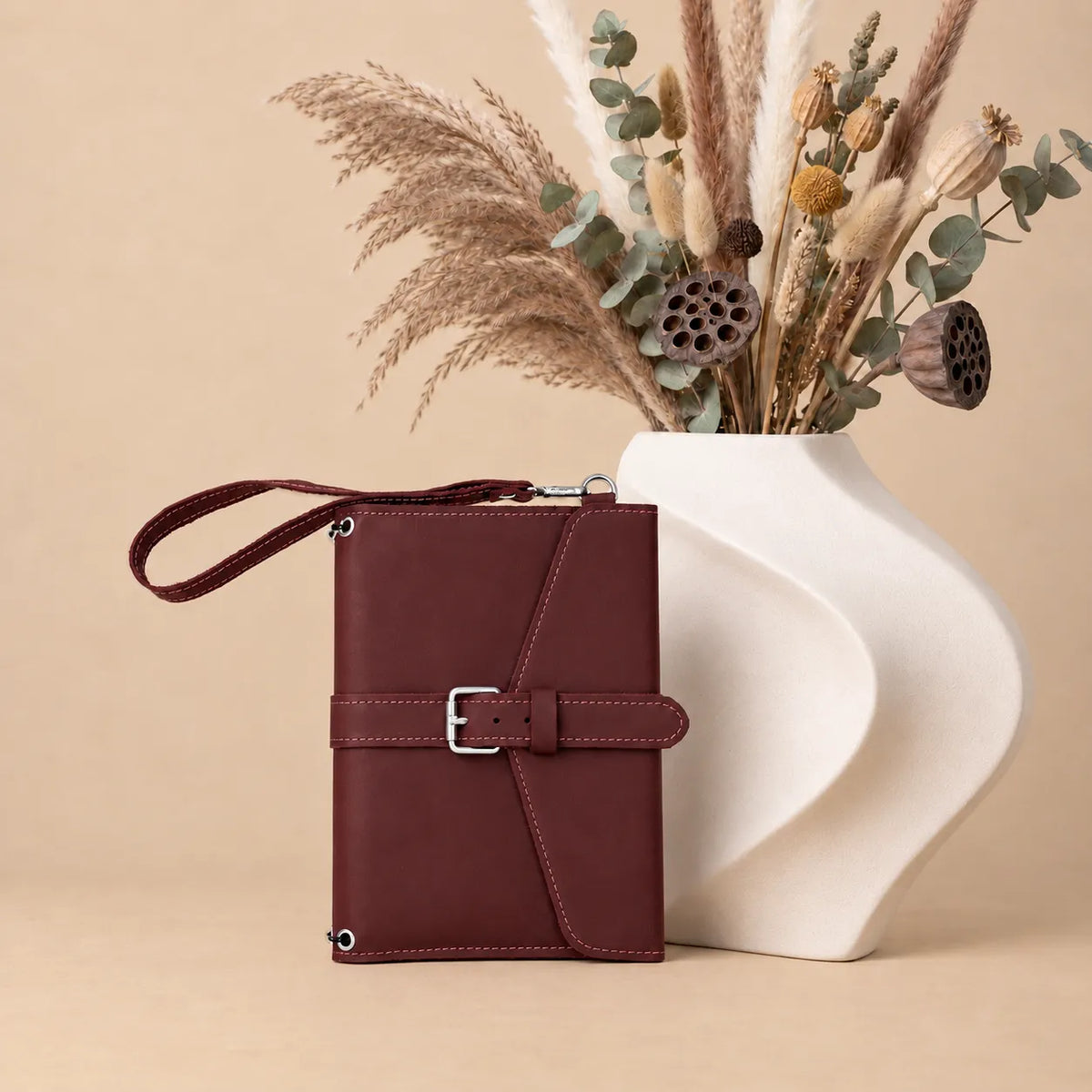 Natural leather notebook cover with organized interior pockets and practical wrist strap