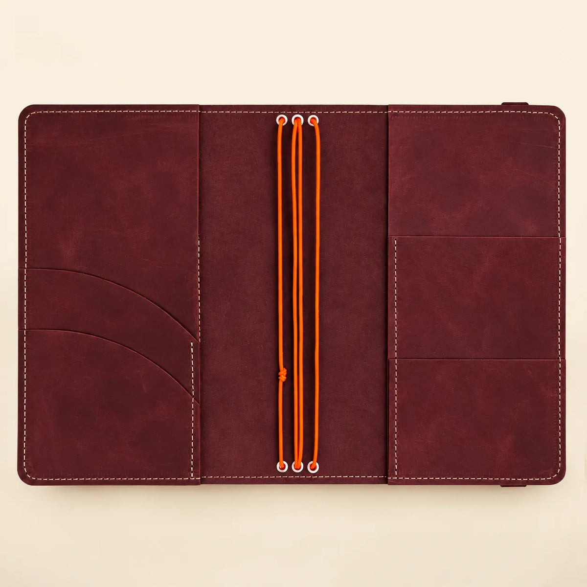 Natural leather journal cover with three elastic bands for inserts and interior pockets.