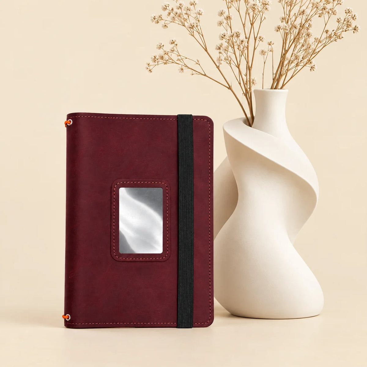Leather notebook cover with interior pockets and three elastic bands holding multiple inserts.