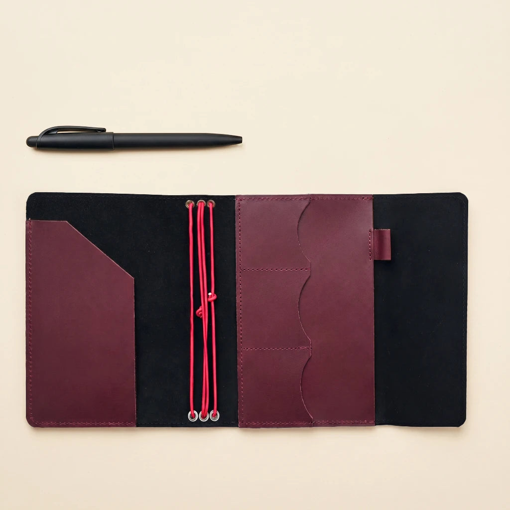 Rustic leather notebook cover with elastic straps, storage pockets, and pen holder