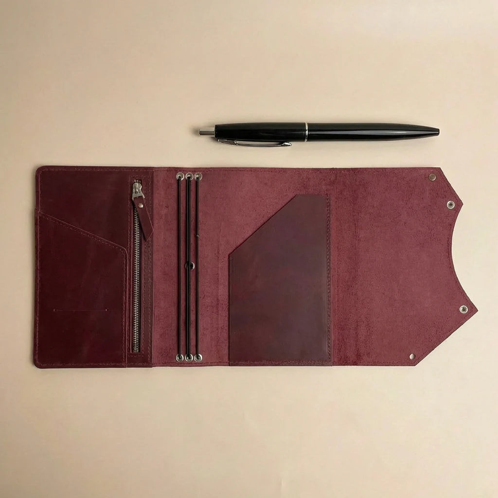Brown leather journal cover with pen on a beige background