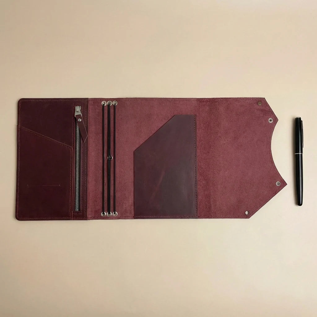 Brown leather journal cover with pen on a beige background