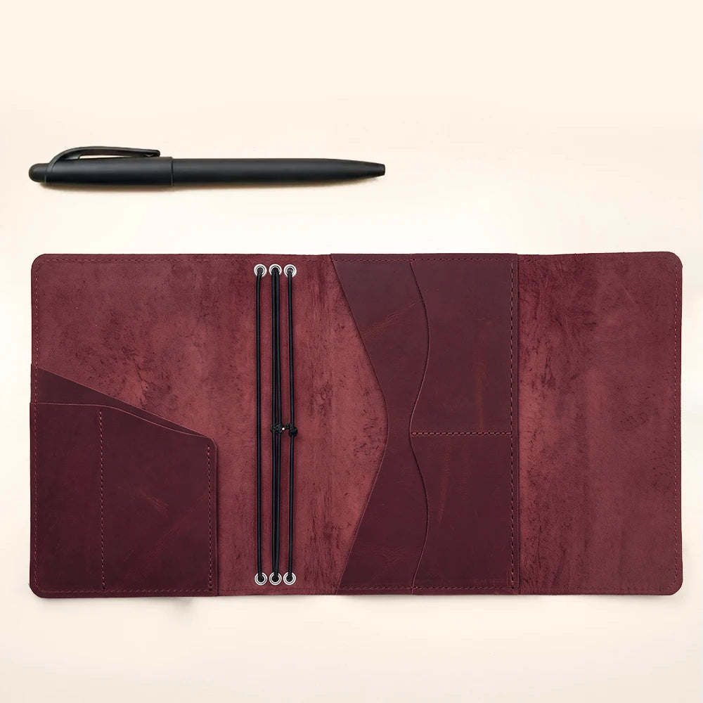 Leather journal cover with three elastic notebook holders and spacious inner storage pockets.