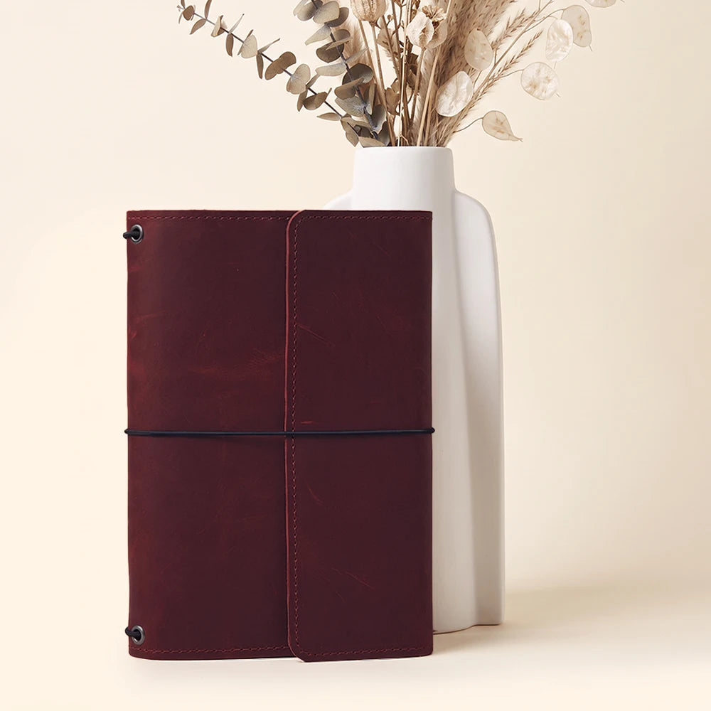 Refillable leather notebook cover with elegant stitching and organized interior storage features.