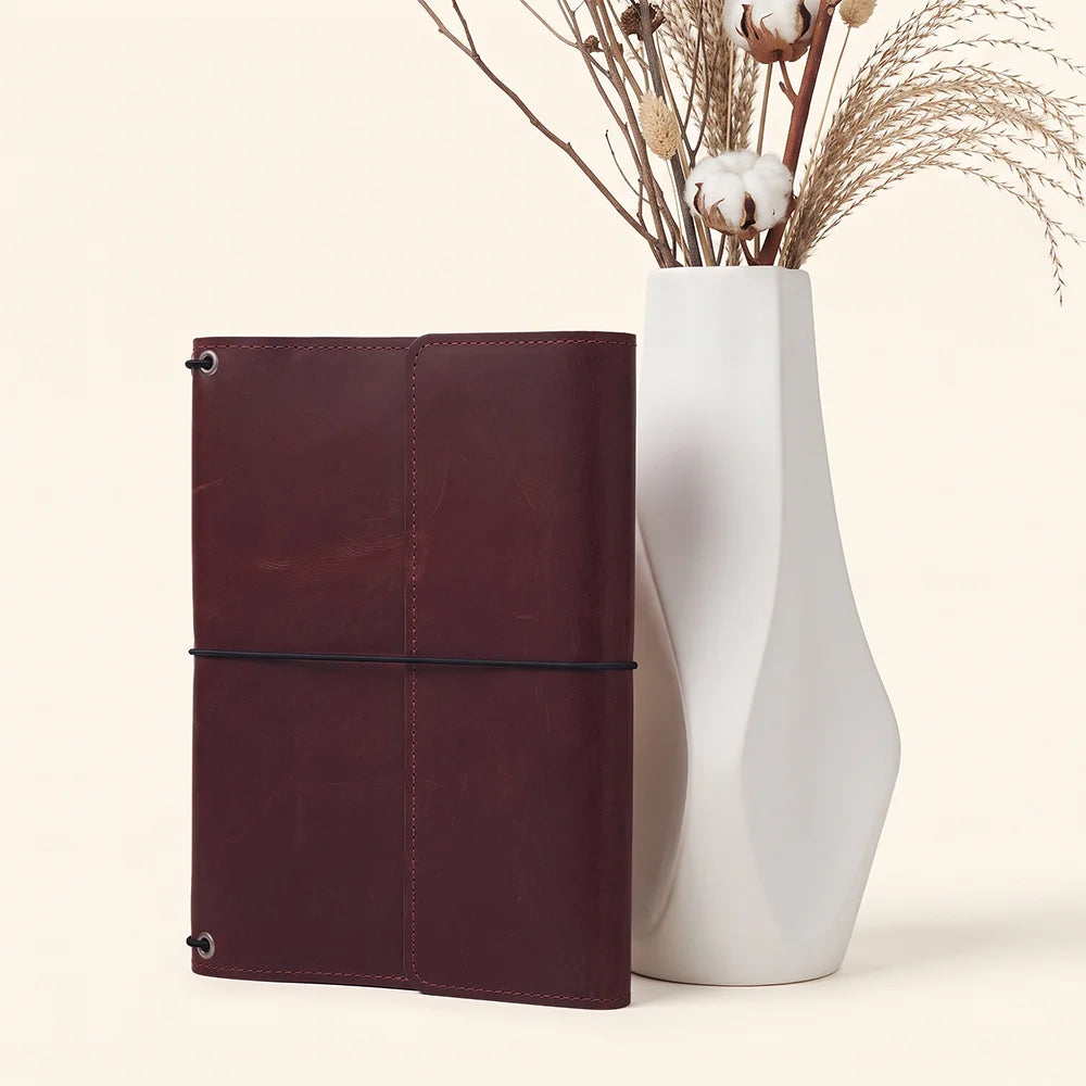 Elegant leather notebook cover featuring three elastic bands and multiple interior organizer pockets.