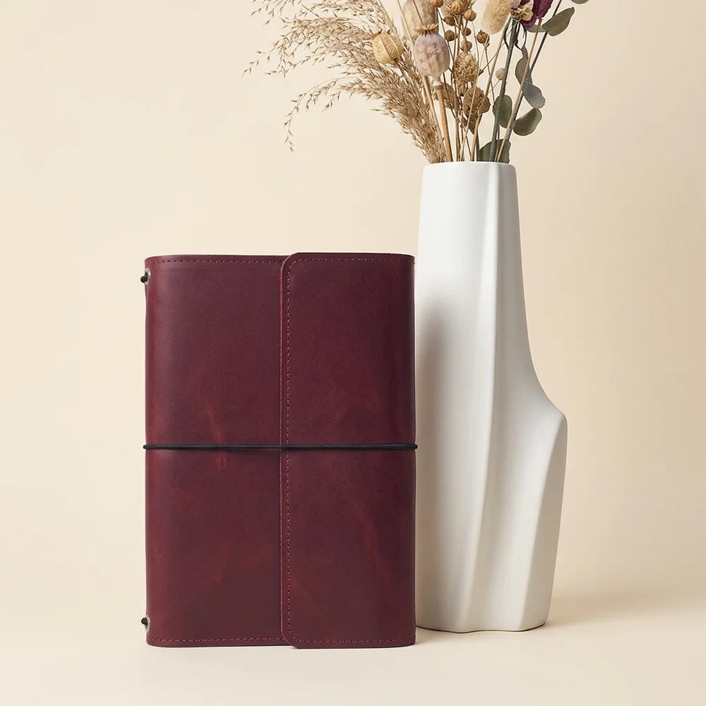 Handmade leather journal organizer with functional compartments for keeping notebooks and pens neatly arranged.