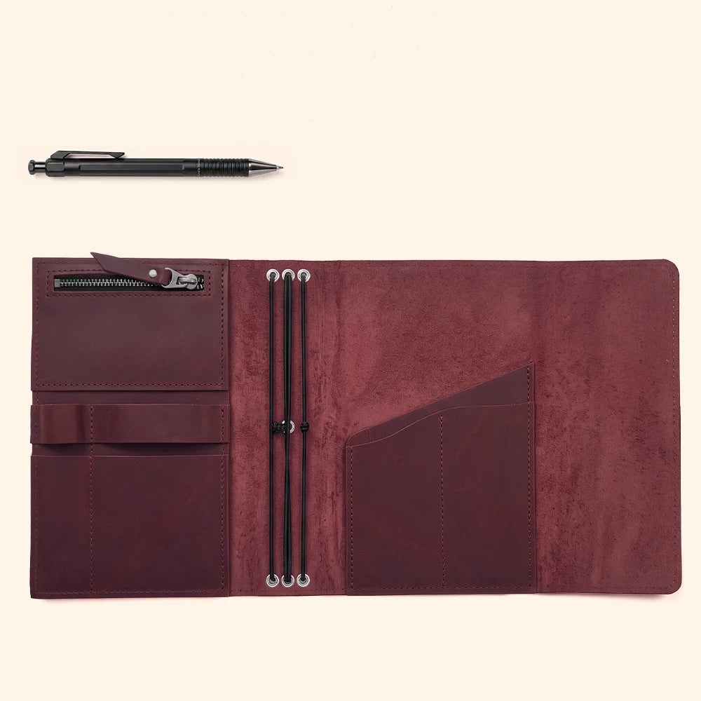 Handmade leather notebook case with thoughtfully arranged interior storage and integrated pen accommodation.