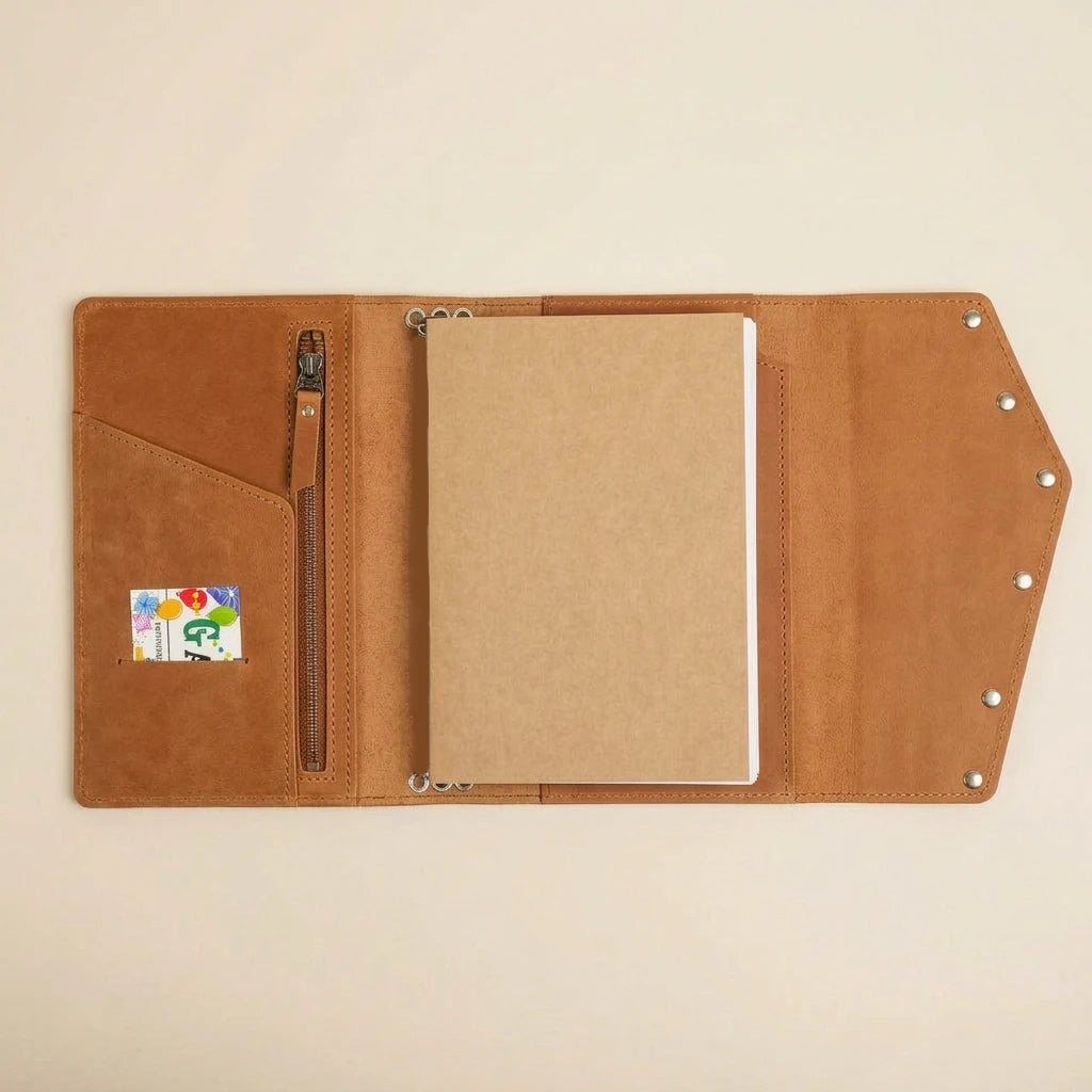 Brown leather journal with a card pocket on a beige background
