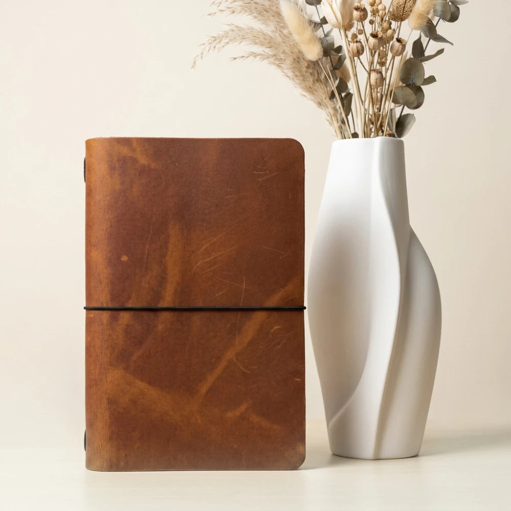 Leather sleeve showing plain notebook pages within a carefully finished cover.