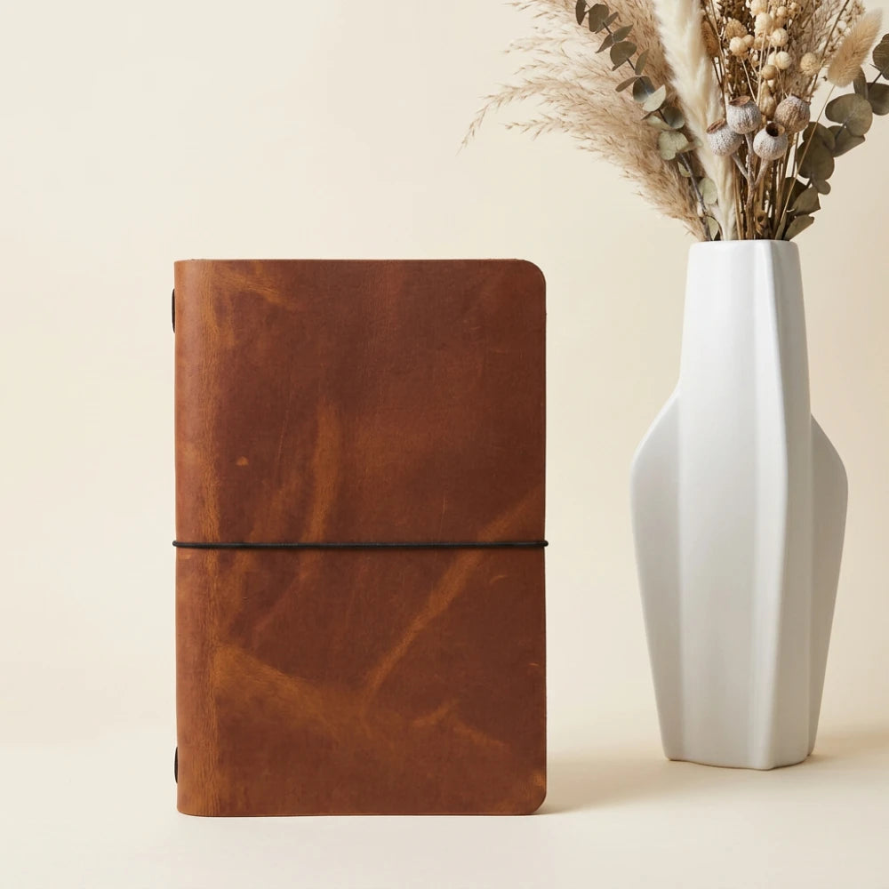 Leather notebook holder featuring simple organization and a flexible elastic retention system.